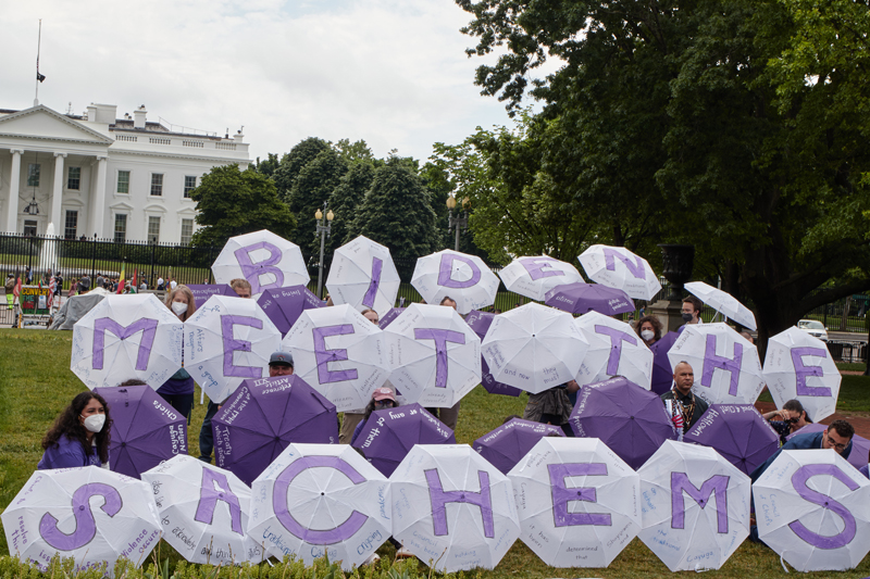 a photo of people in Washington, D.C. with white and purple umbrellas that spell out 'Biden Meet the Sachems'